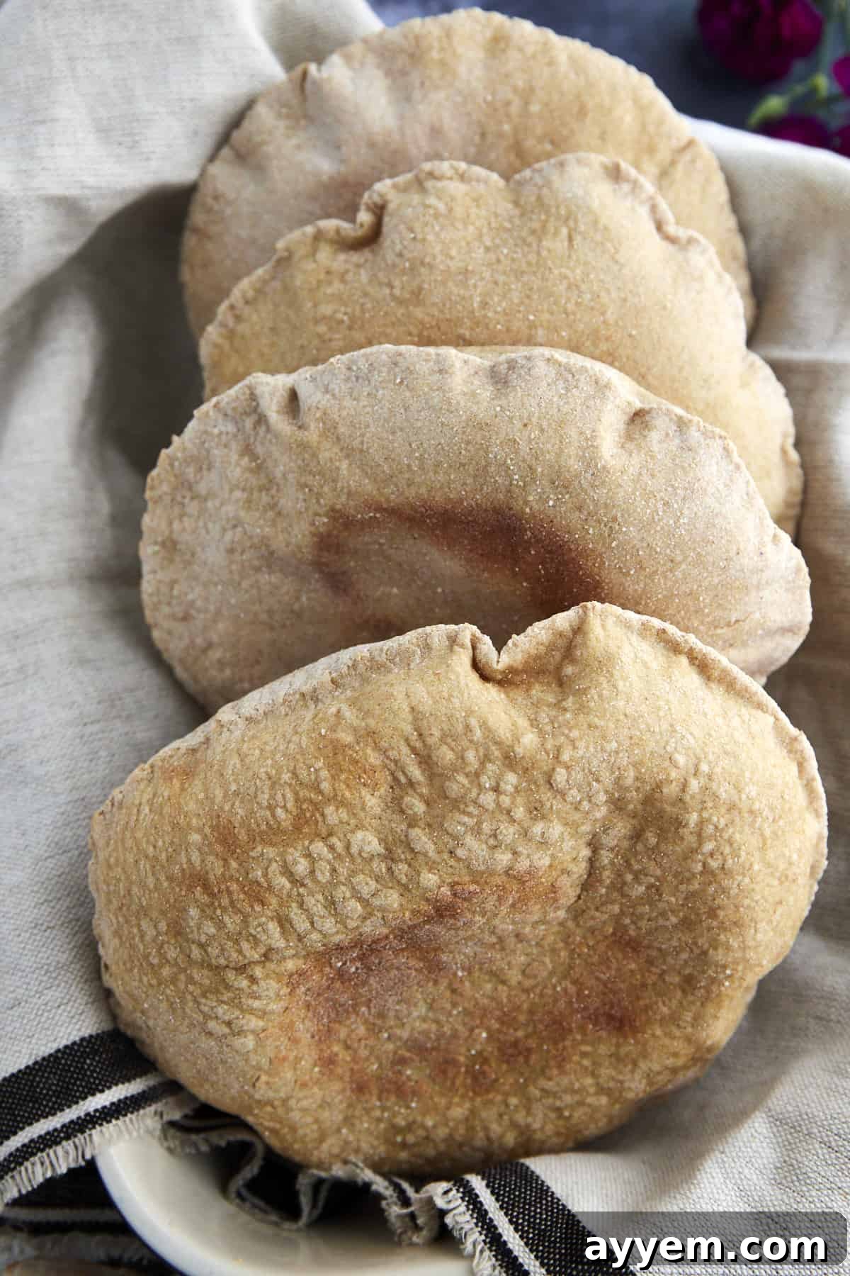 four whole wheat pita bread pockets in a basket
