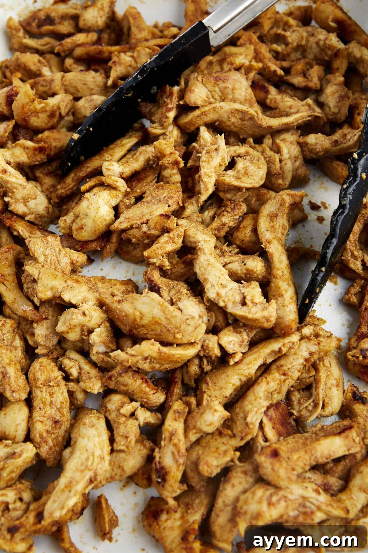 Perfectly baked shawarma chicken pieces, golden-brown and glistening, arranged neatly on a baking sheet, showcasing their crisp edges and tender interior.