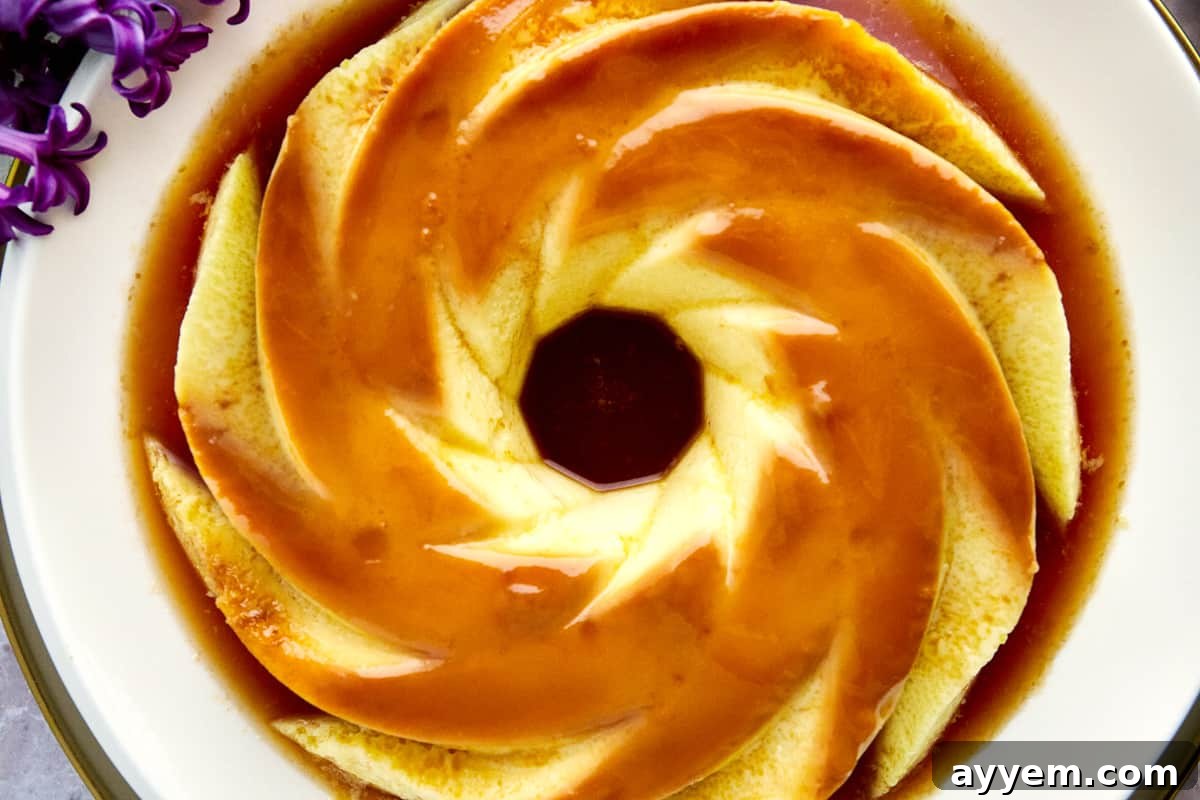 Overhead image of a beautifully presented creme caramel flan on a plate, surrounded by its rich caramel sauce.