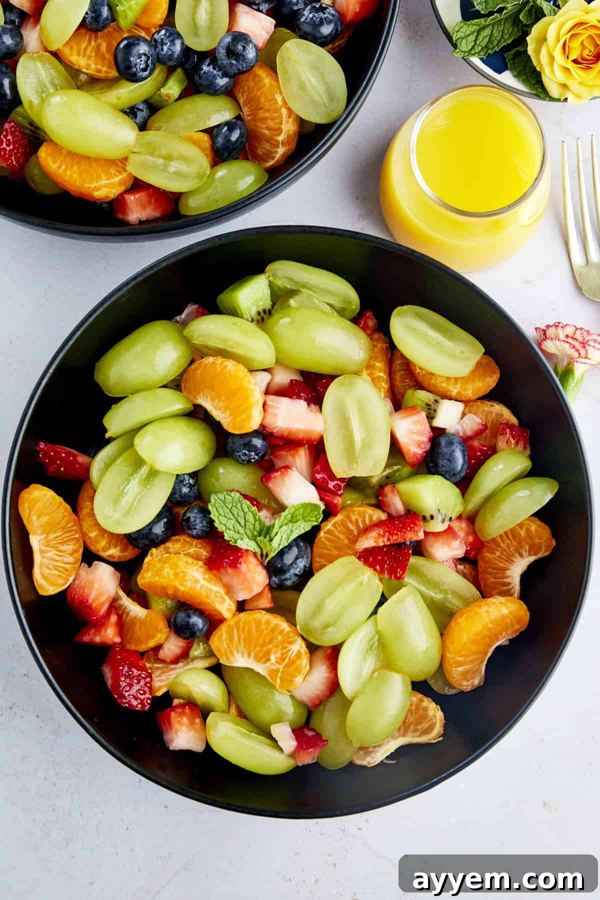 Easy Fruit Salad recipe with blueberries, strawberries, grapes, clementines, kiwis, and mint tossed with a sweet citrus dressing.