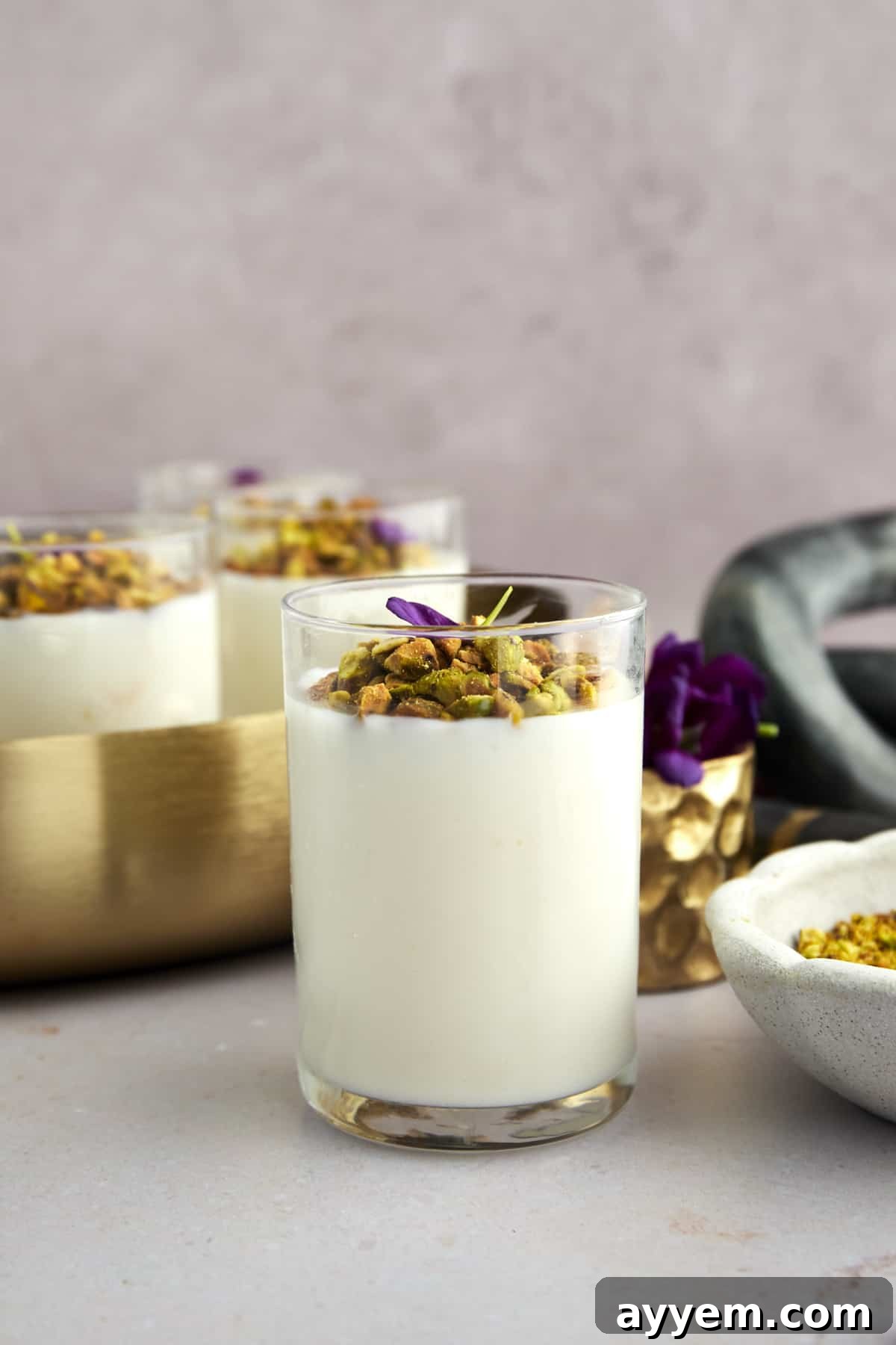 A bowl of freshly made Mahalabia with a spoon, ready to be chilled.