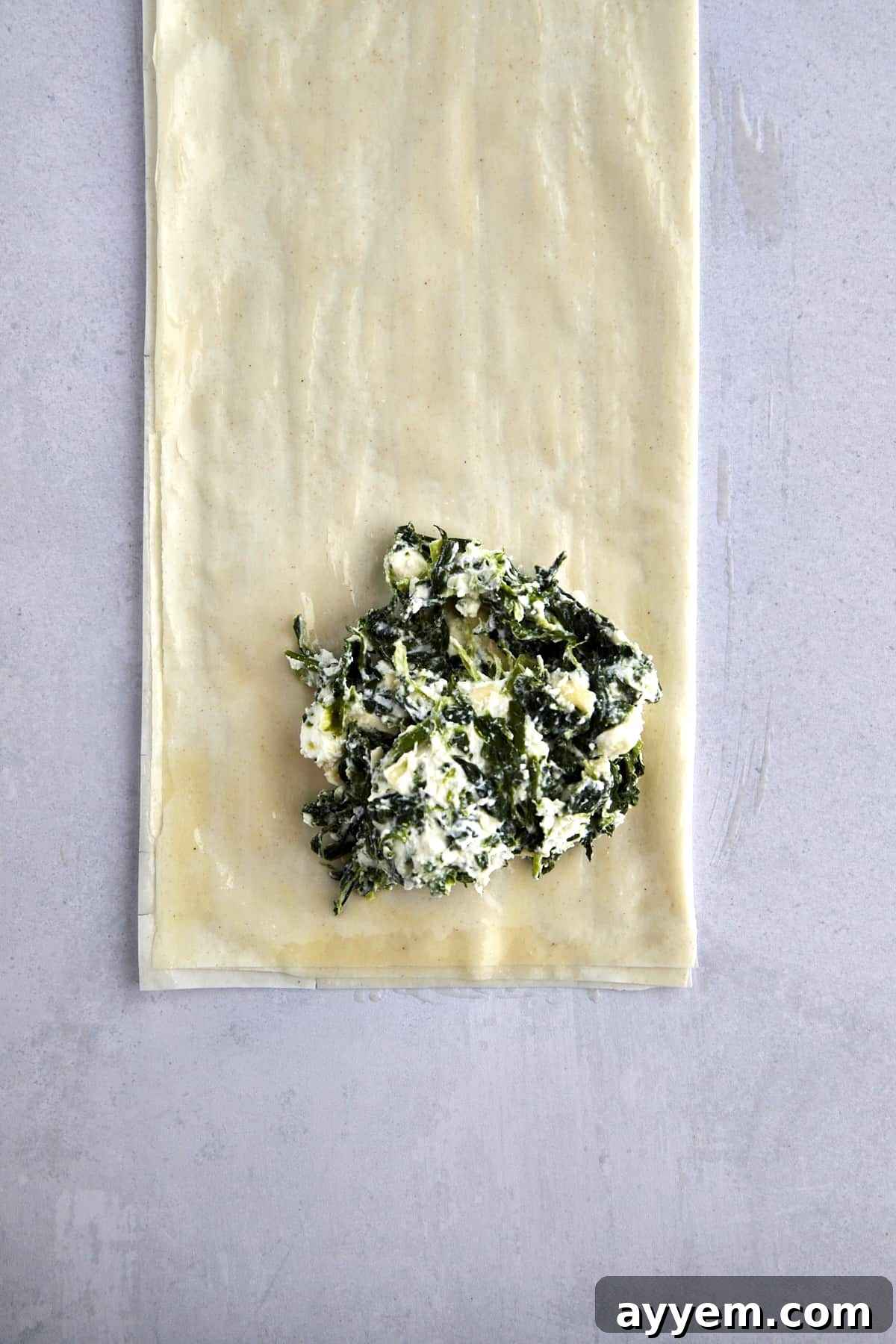 A dollop of spinach cream cheese filling over buttered layers of phyllo dough. 
