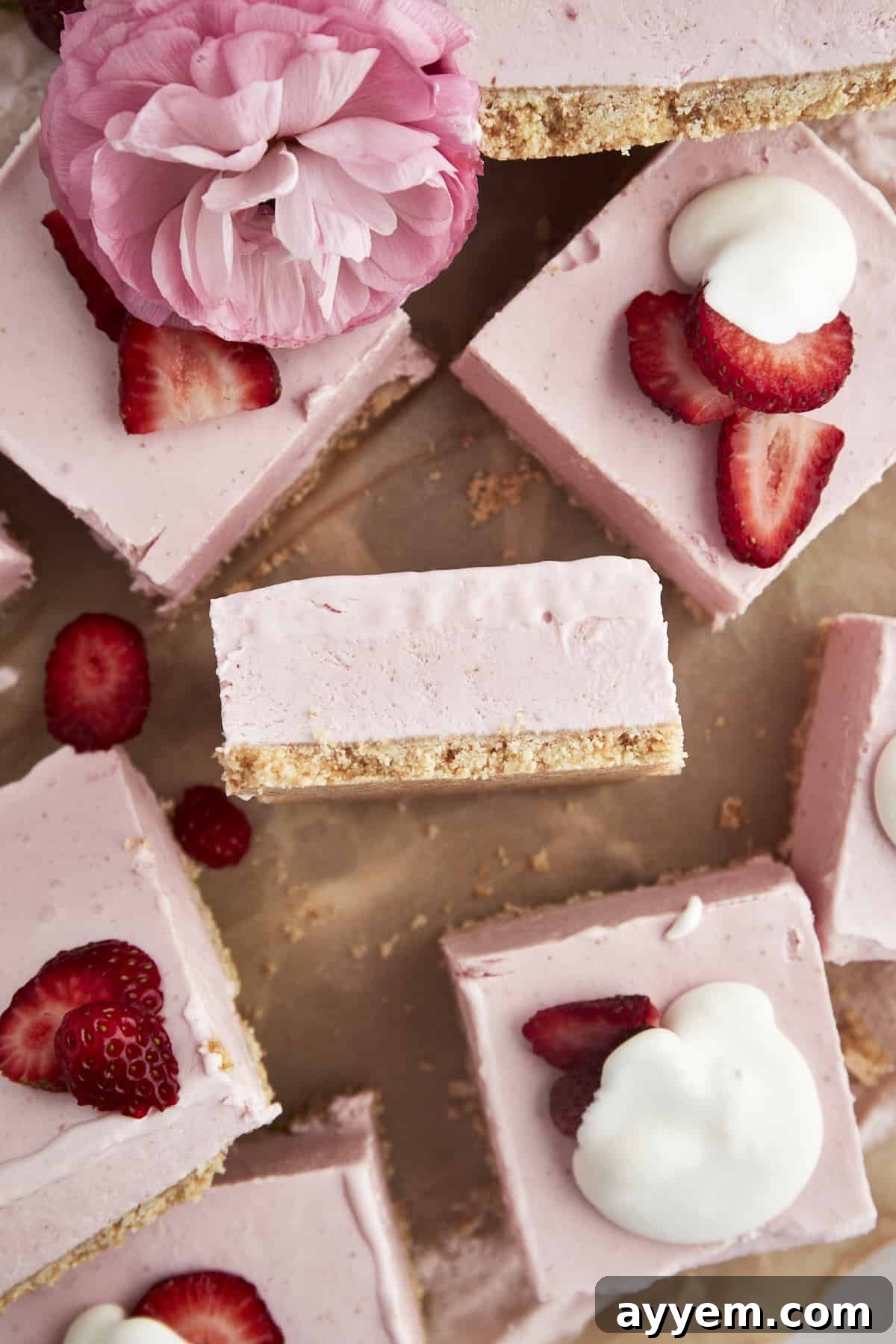No-bake strawberry cheesecake squares topped with fresh strawberries and a dollop of whipped cream.