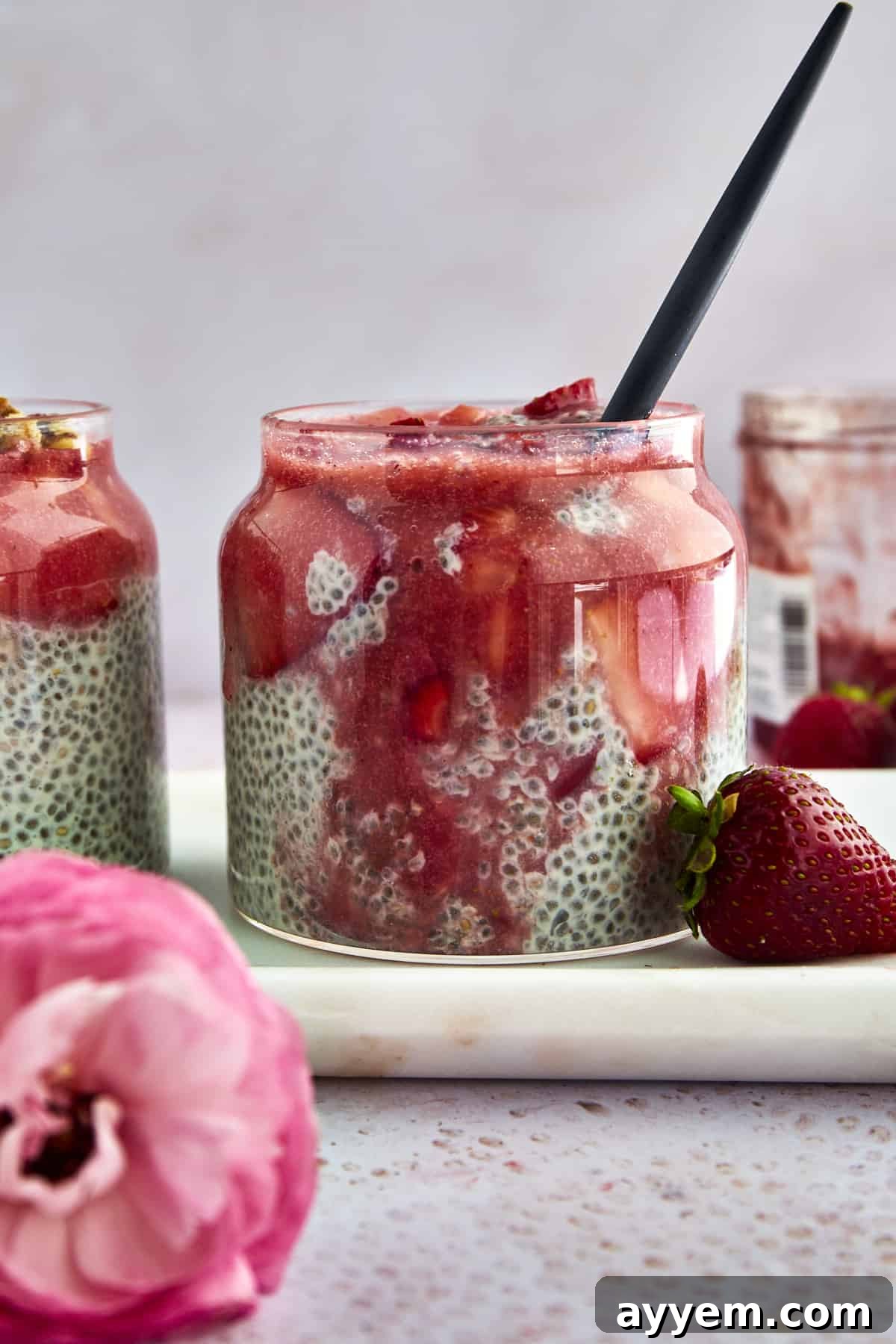 A jar of strawberry chia pudding with strawberry puree mixed in.