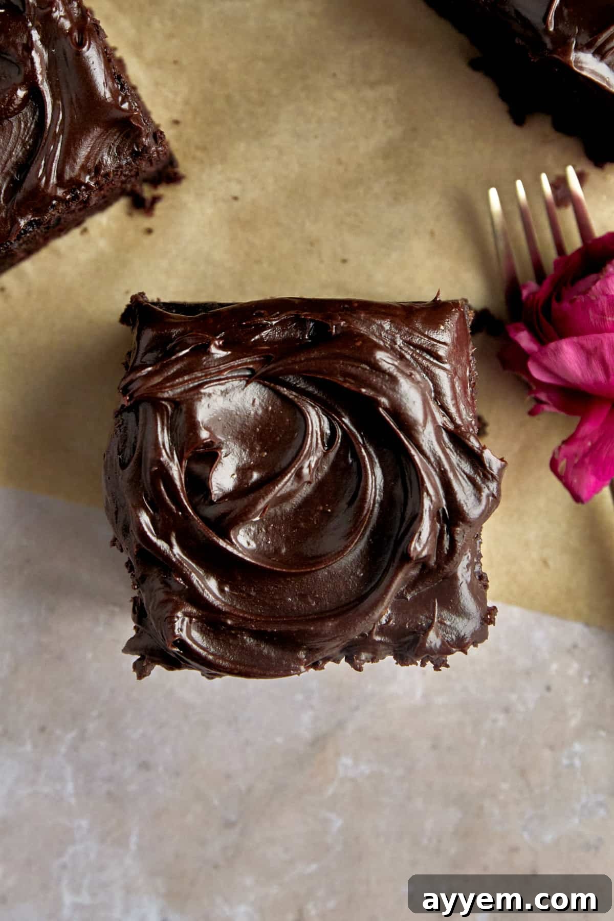 Overhead image of chocolate frosting on top of a square of zucchini cake. 