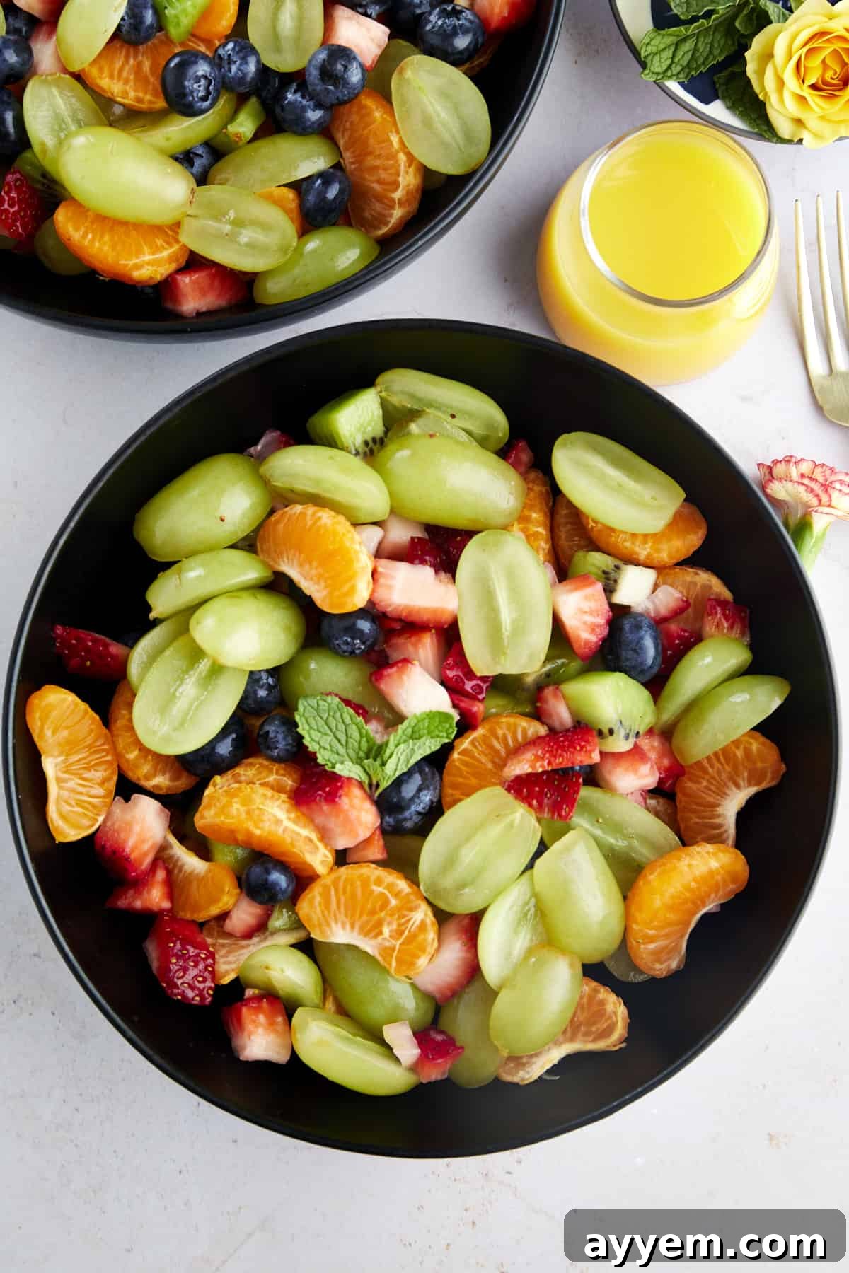 Easter Feast Over 25 Essential Recipes for All Your Celebrations 12 An inviting overhead image of a bowl of refreshing fruit salad, glistening with a vibrant orange juice dressing served on the side, a perfect light accompaniment to any meal.