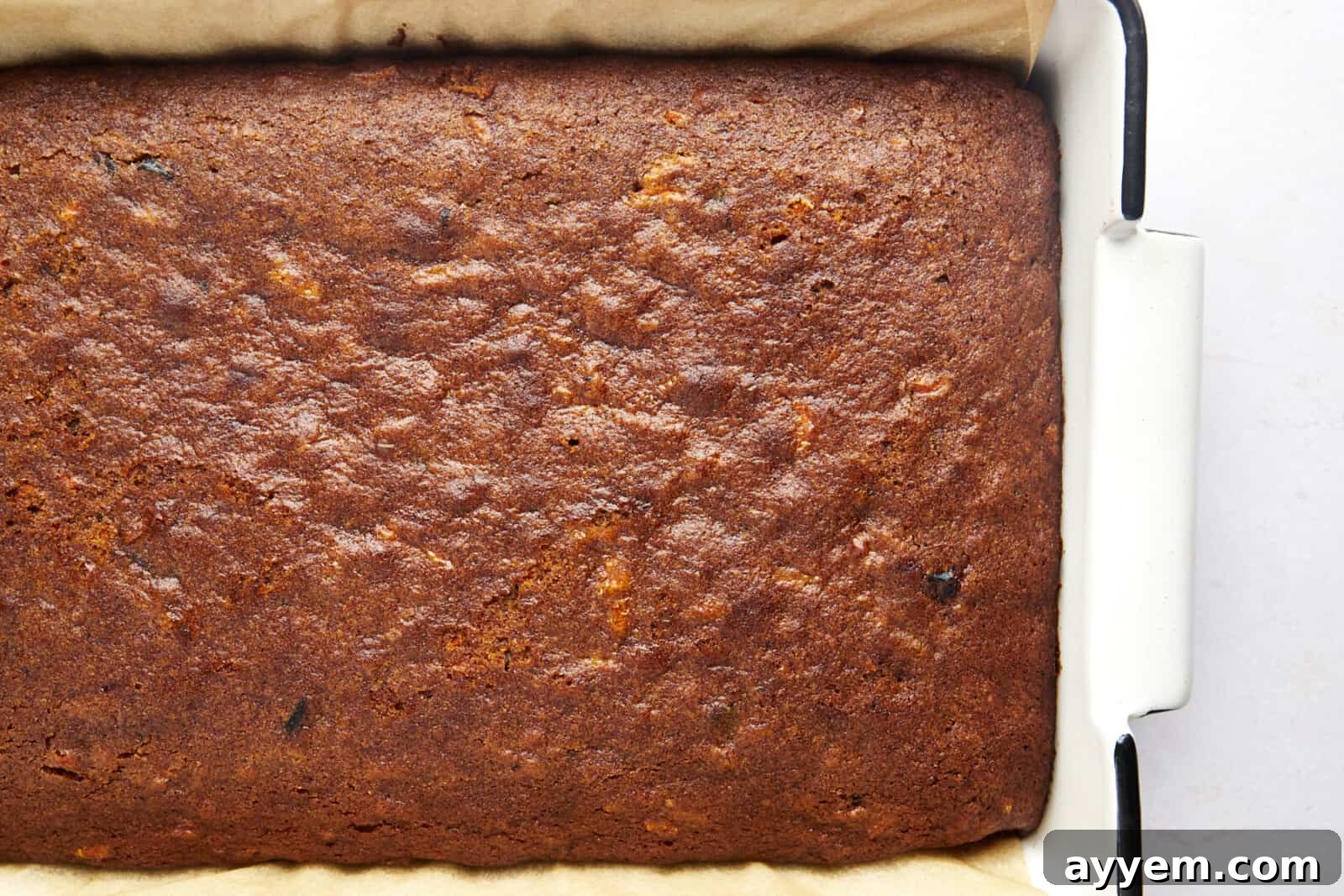 Overhead image of freshly baked carrot cake in a baking pan, cooling.