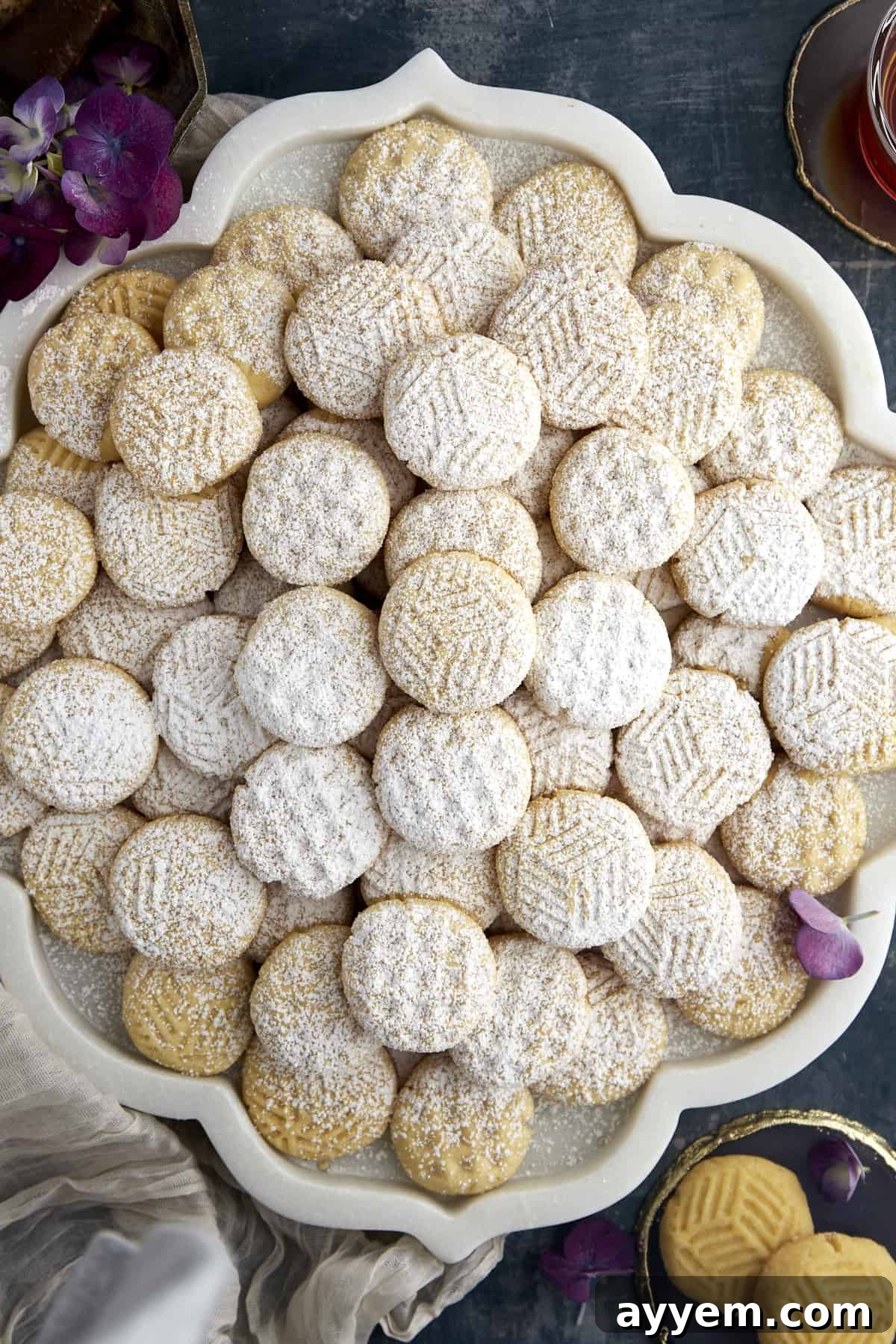 A platter of plain kahk cookies dusted with powdered sugar.