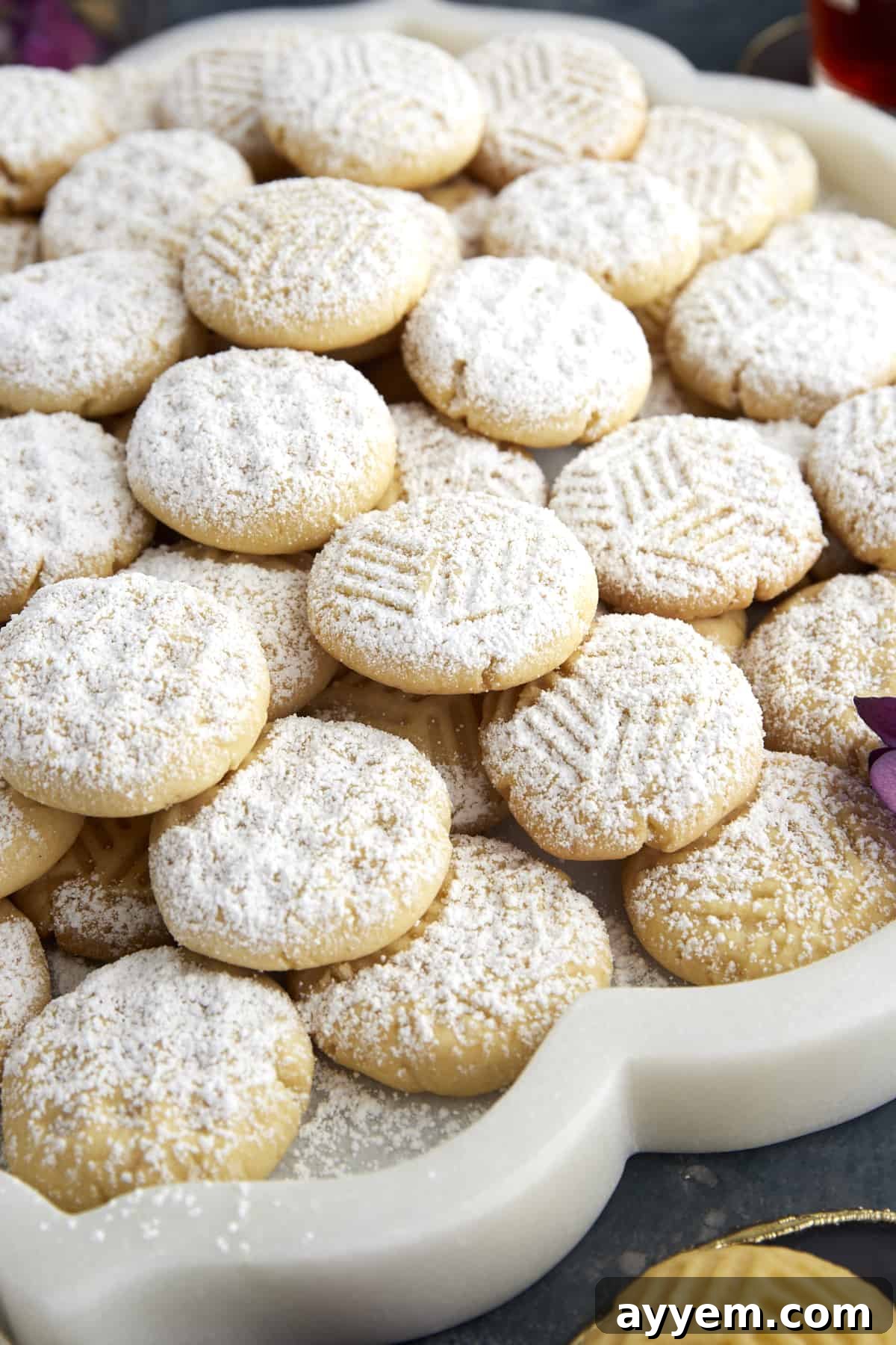 Kahk Cookies with geometric designs topped with powdered sugar.
