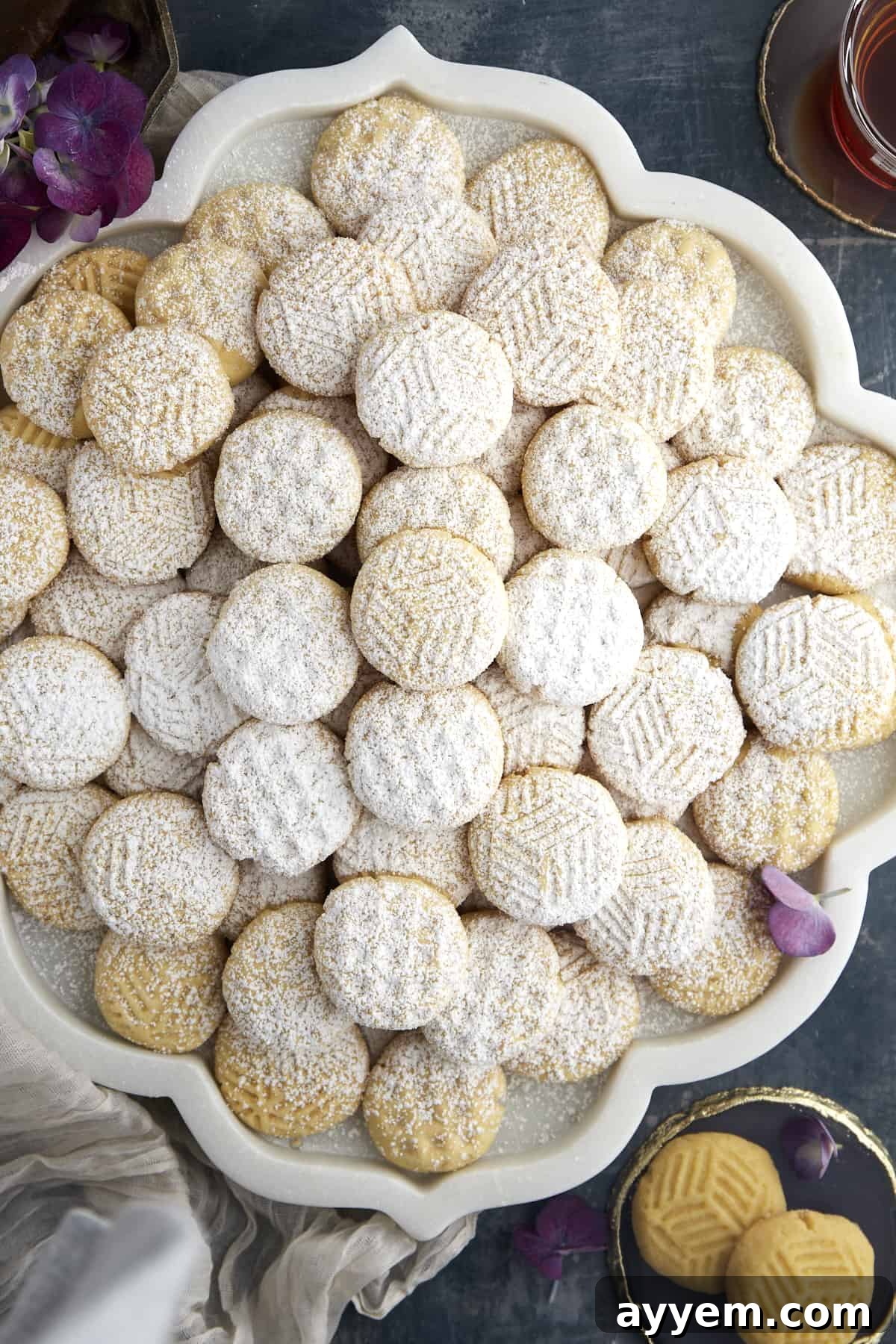 A platter of plain kahk cookies dusted with powdered sugar.