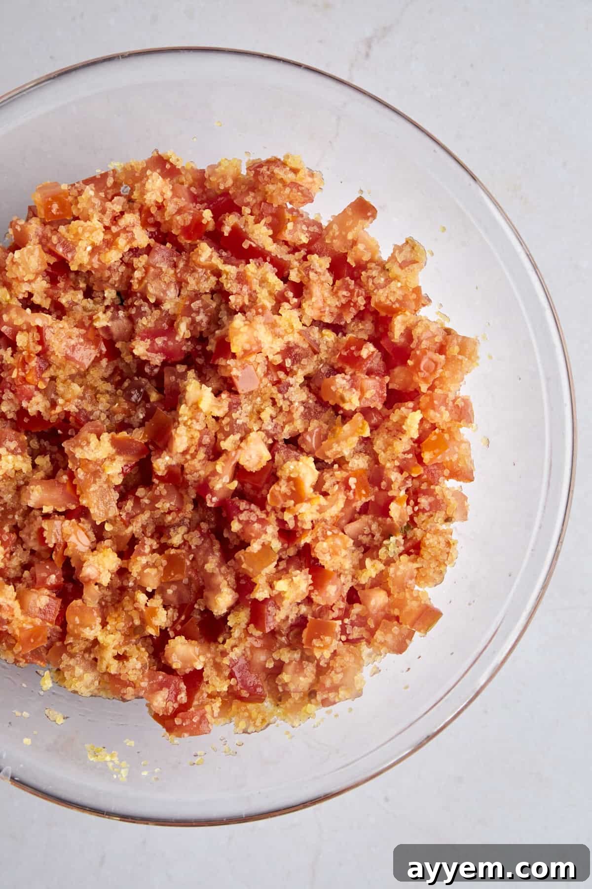 A bowl of bulgur wheat with chopped tomatoes.