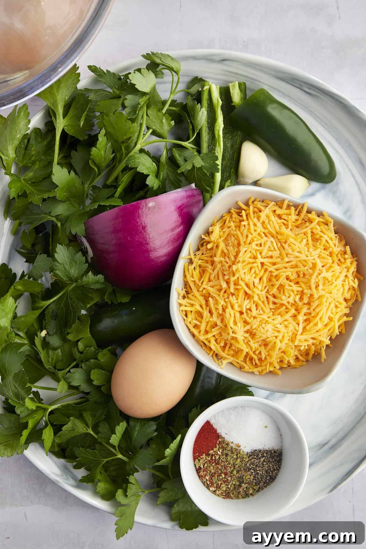 Fresh parsley, shredded Cheddar cheese, red onion, jalapeño, garlic cloves, an egg, and spices. 