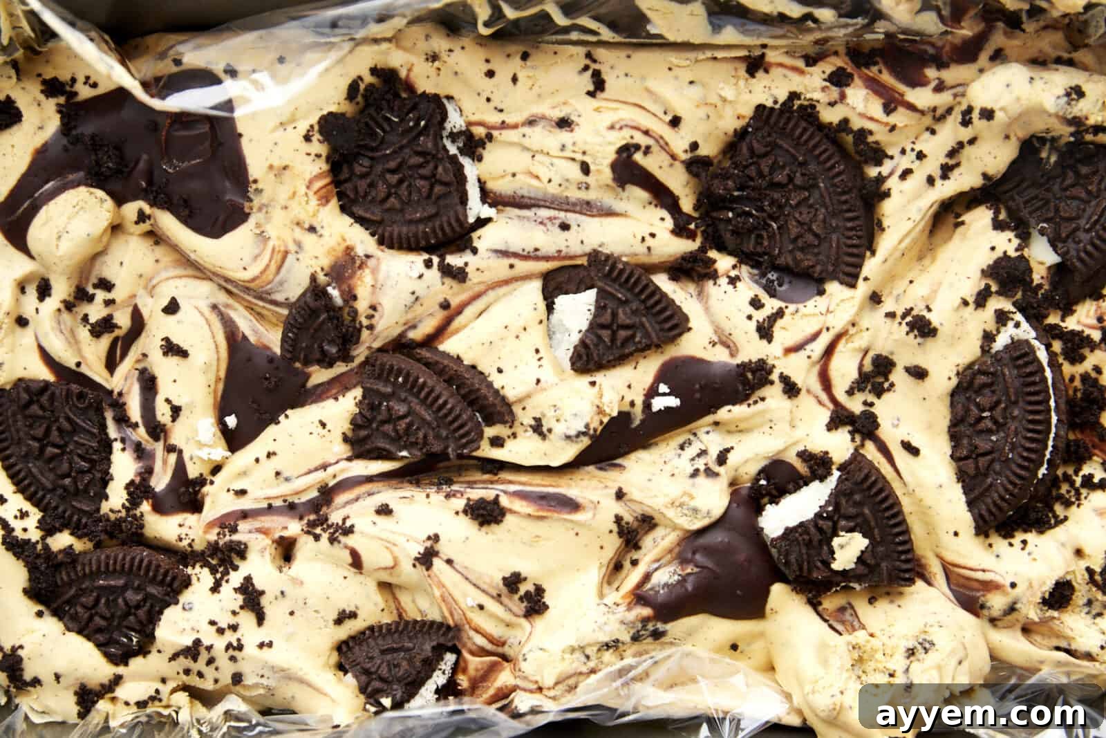 Overhead image of mocha Oreo no churn ice cream topped with Oreo chunks in a loaf pan.