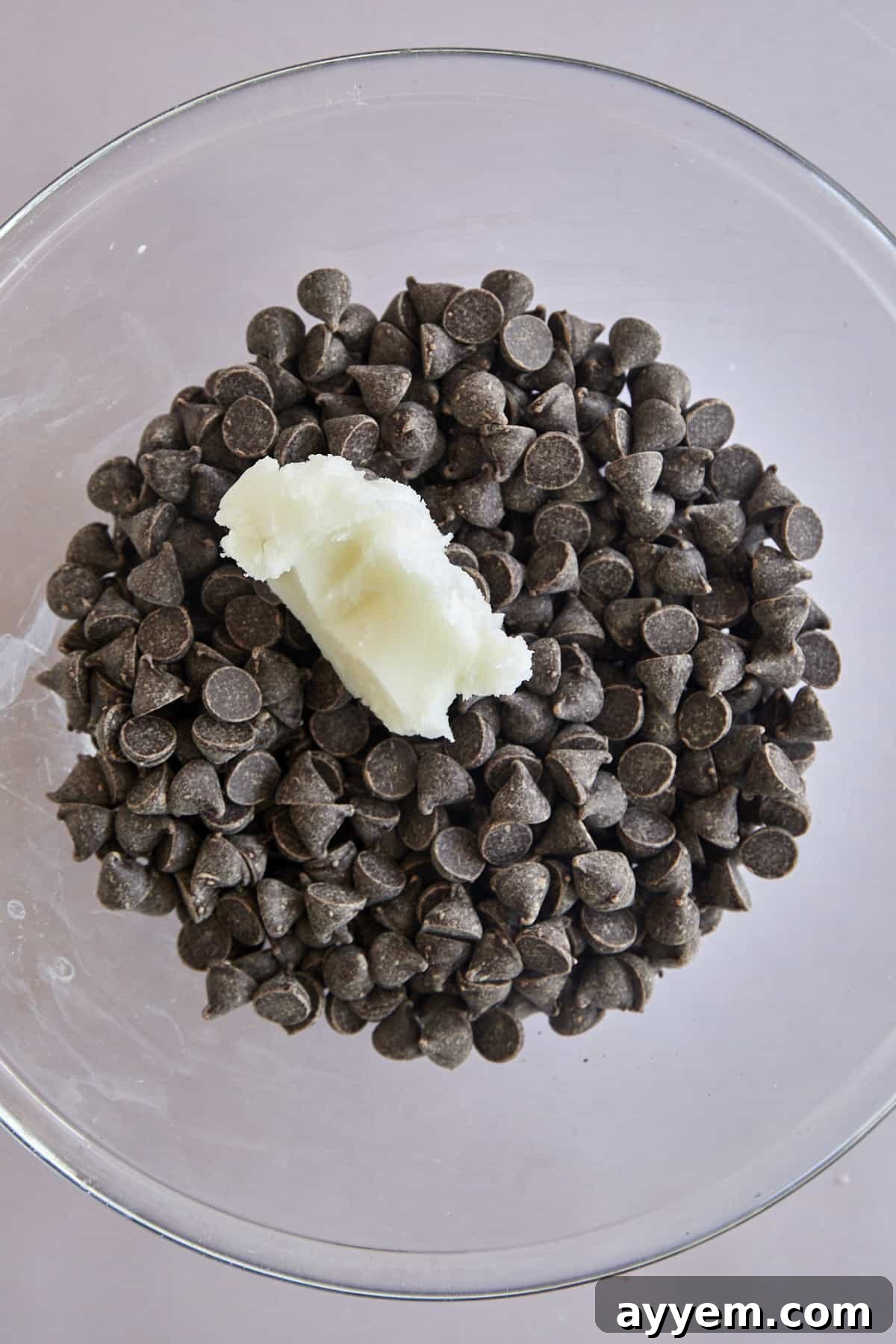 A bowl filled with semi-sweet chocolate chips and a dollop of coconut oil, ready for melting.