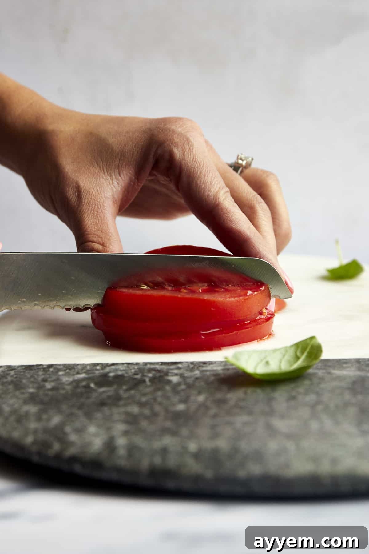 Mastering Tomato Slices Three Essential Techniques 5 A stack of freshly cut tomato slices being diced into small, even cubes on a cutting board, demonstrating the cross-cutting technique.
