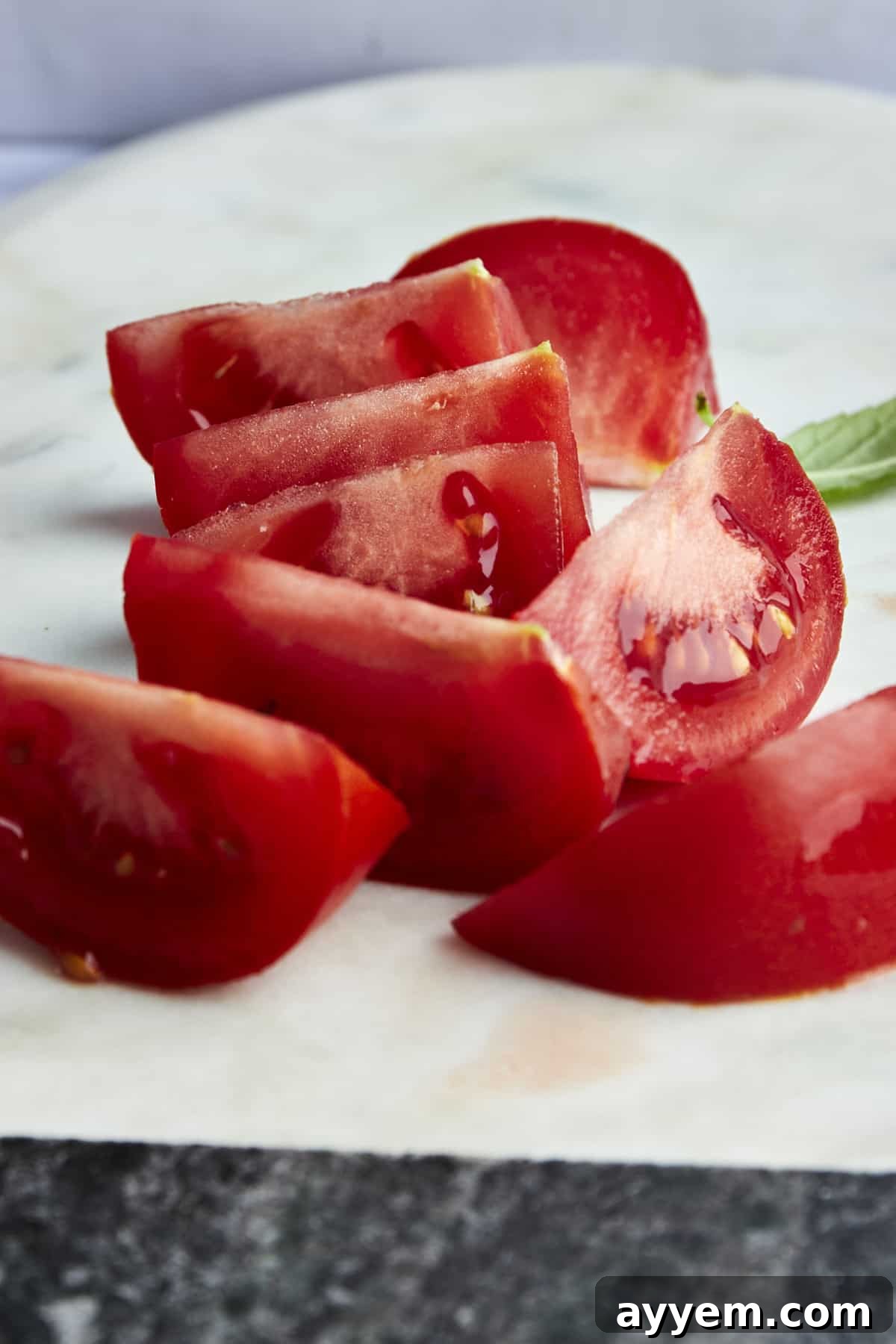 Mastering Tomato Slices Three Essential Techniques 7 Freshly cut tomato wedges arranged beautifully on a wooden cutting board, ready for use in a recipe.