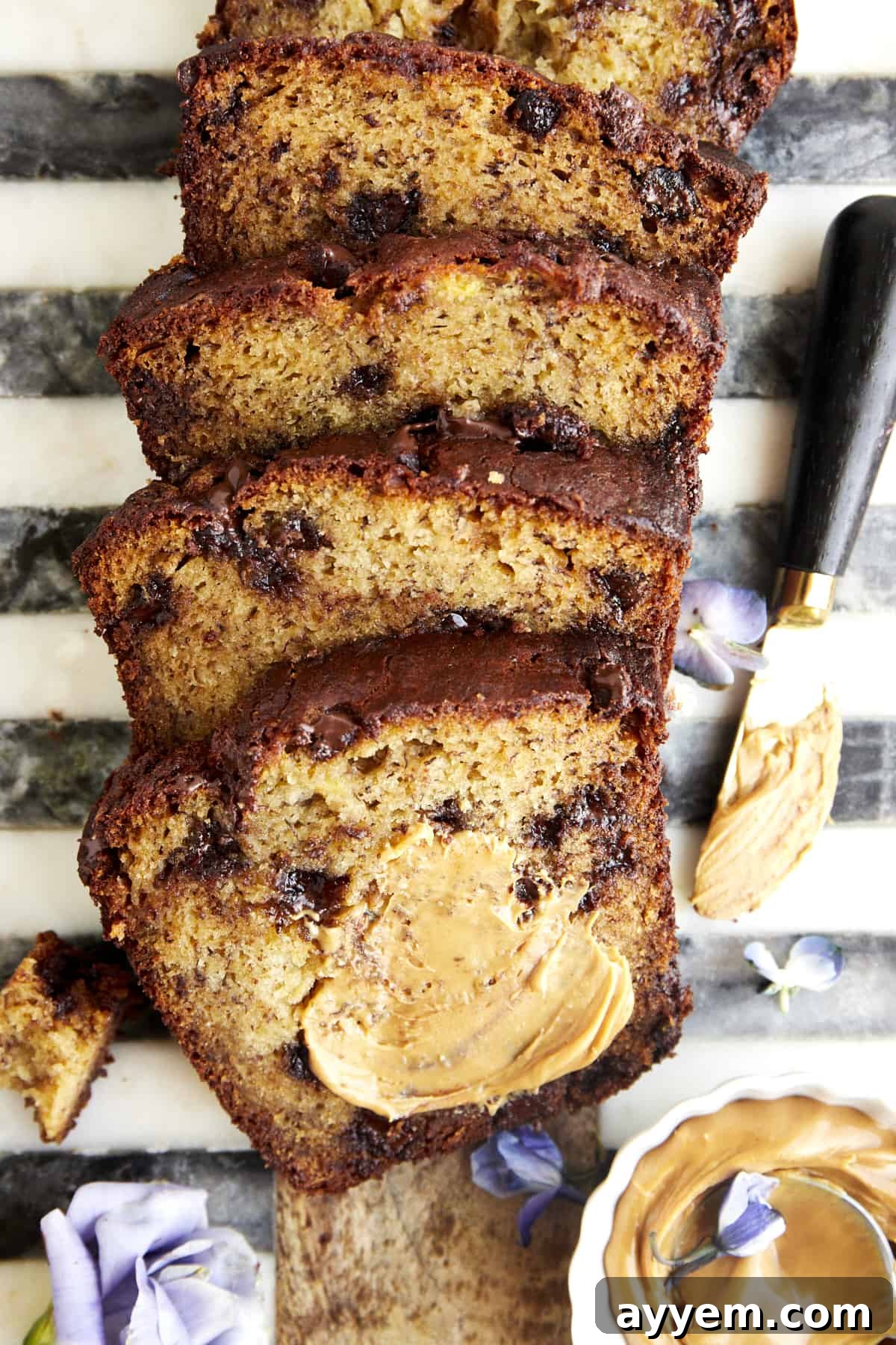 Chocolate chip peanut butter banana bread with peanut butter smeared over the top piece.