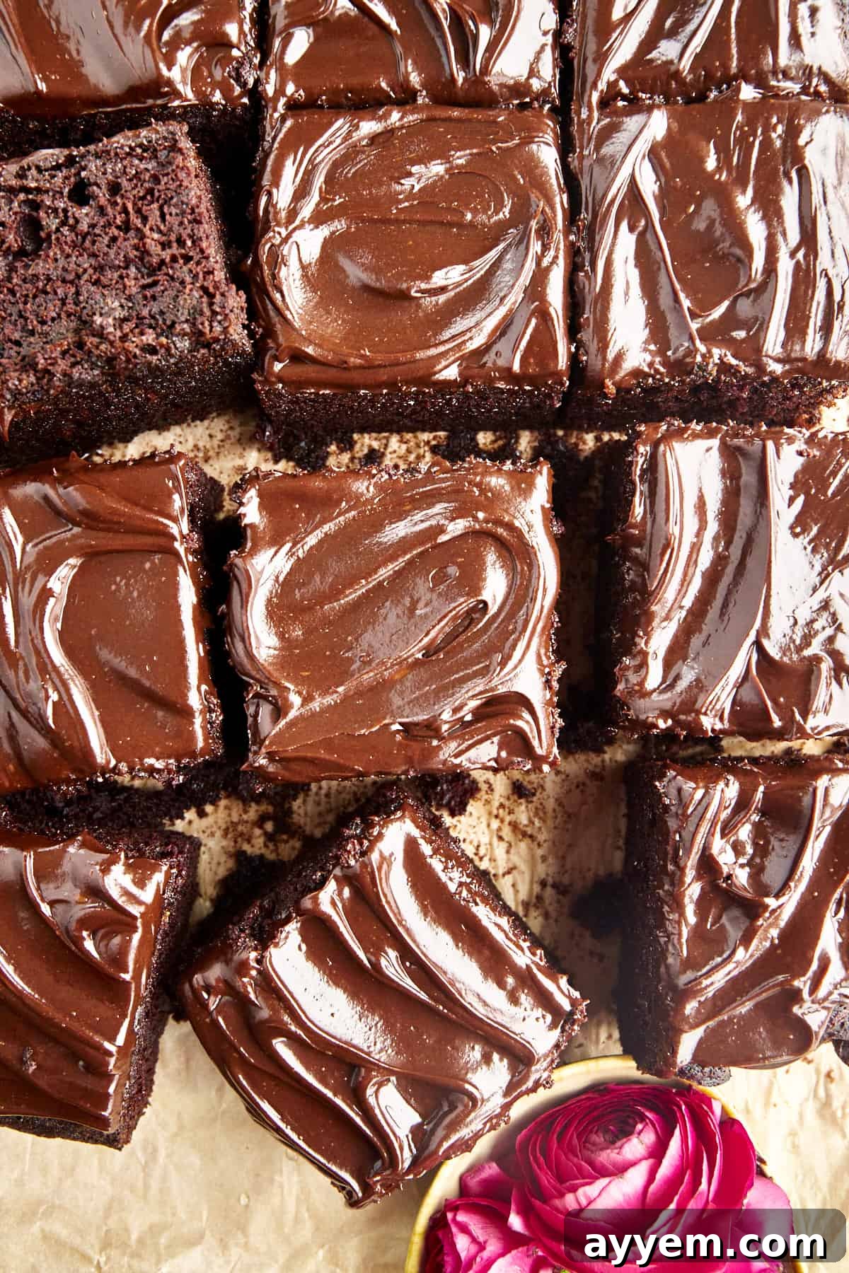 A slice of rich chocolate zucchini cake with creamy frosting and chocolate shavings.