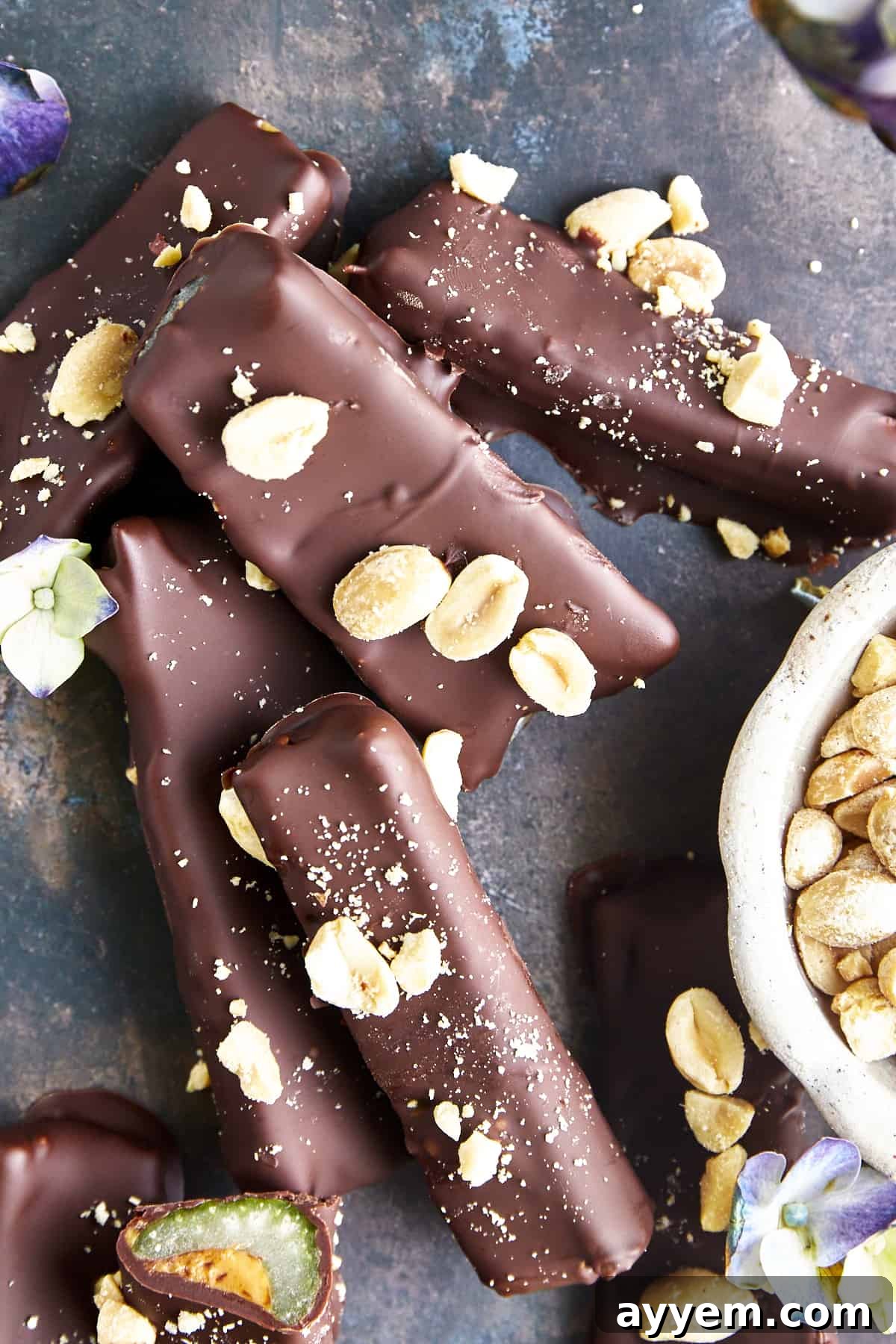 Overhead image of chocolate dipped celery with peanut butter logs topped with peanuts and sea salt. A perfect healthy and indulgent snack.