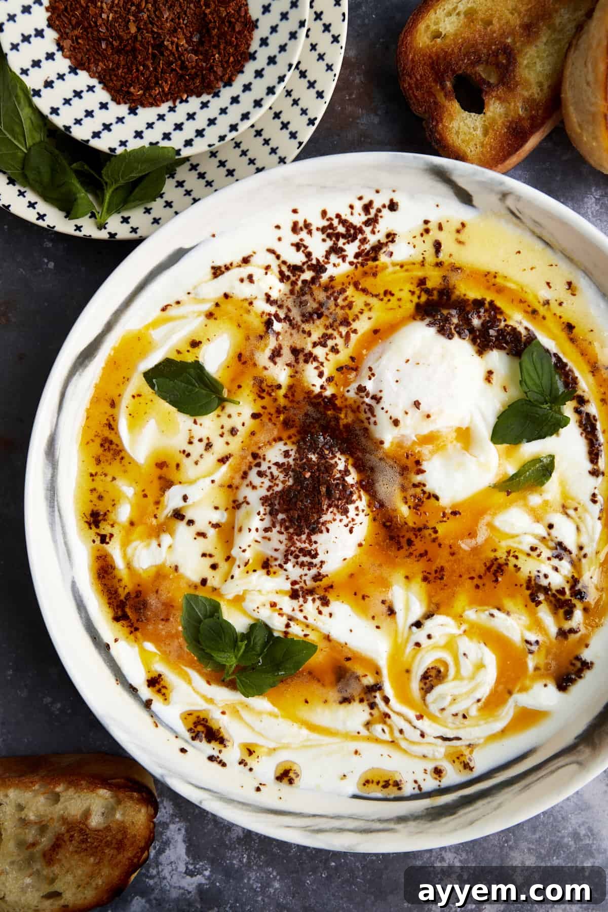Anatolian Poached Eggs with Cottage Cheese 5 Overhead image of a bowl of Turkish Poached Eggs with Cottage Cheese topped with Aleppo pepper, ready to be enjoyed.