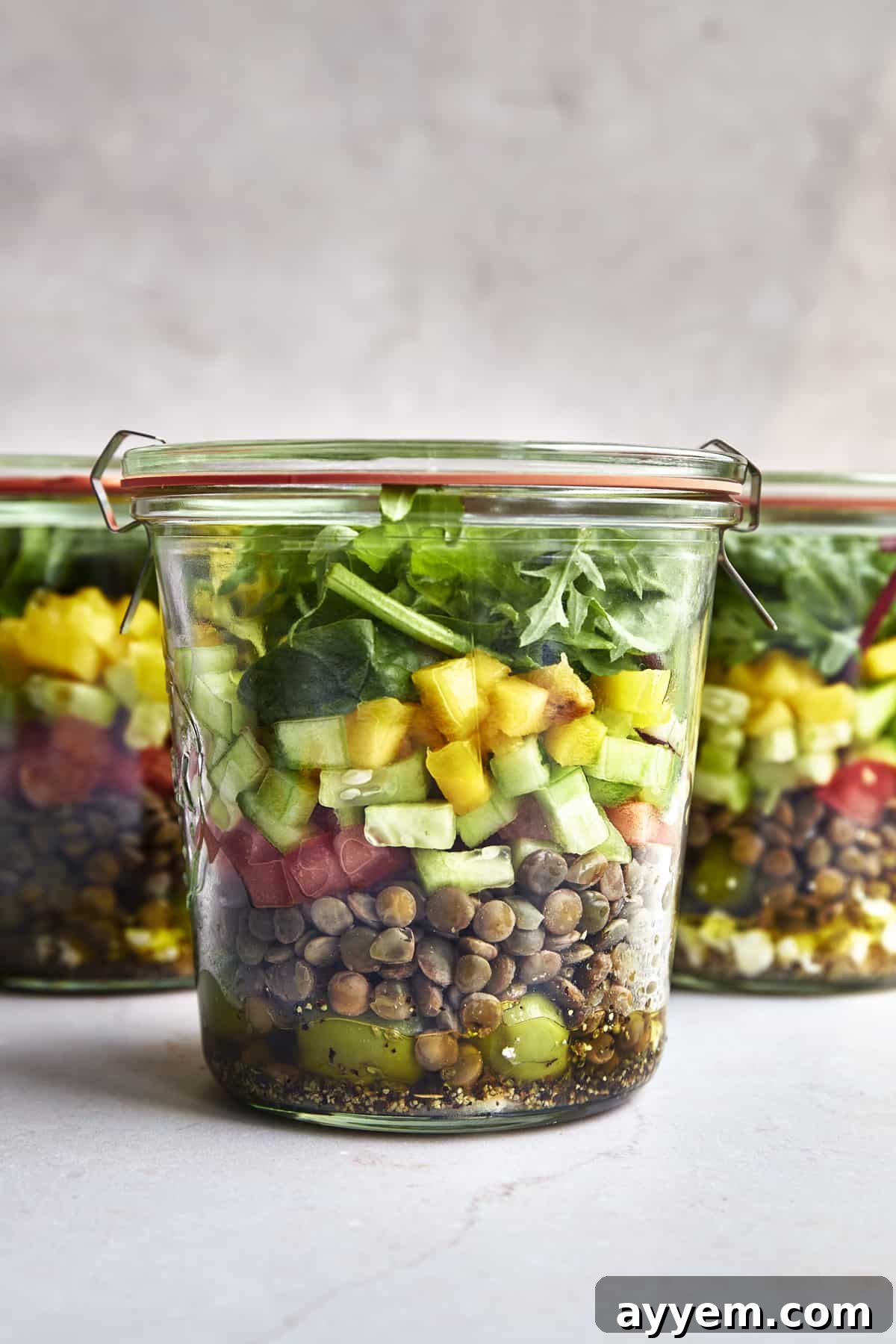 Sunshine Mango Jar Salad 3 Multiple Mason Jar Salads with Mango, neatly arranged, showcasing vibrant layers of fresh ingredients