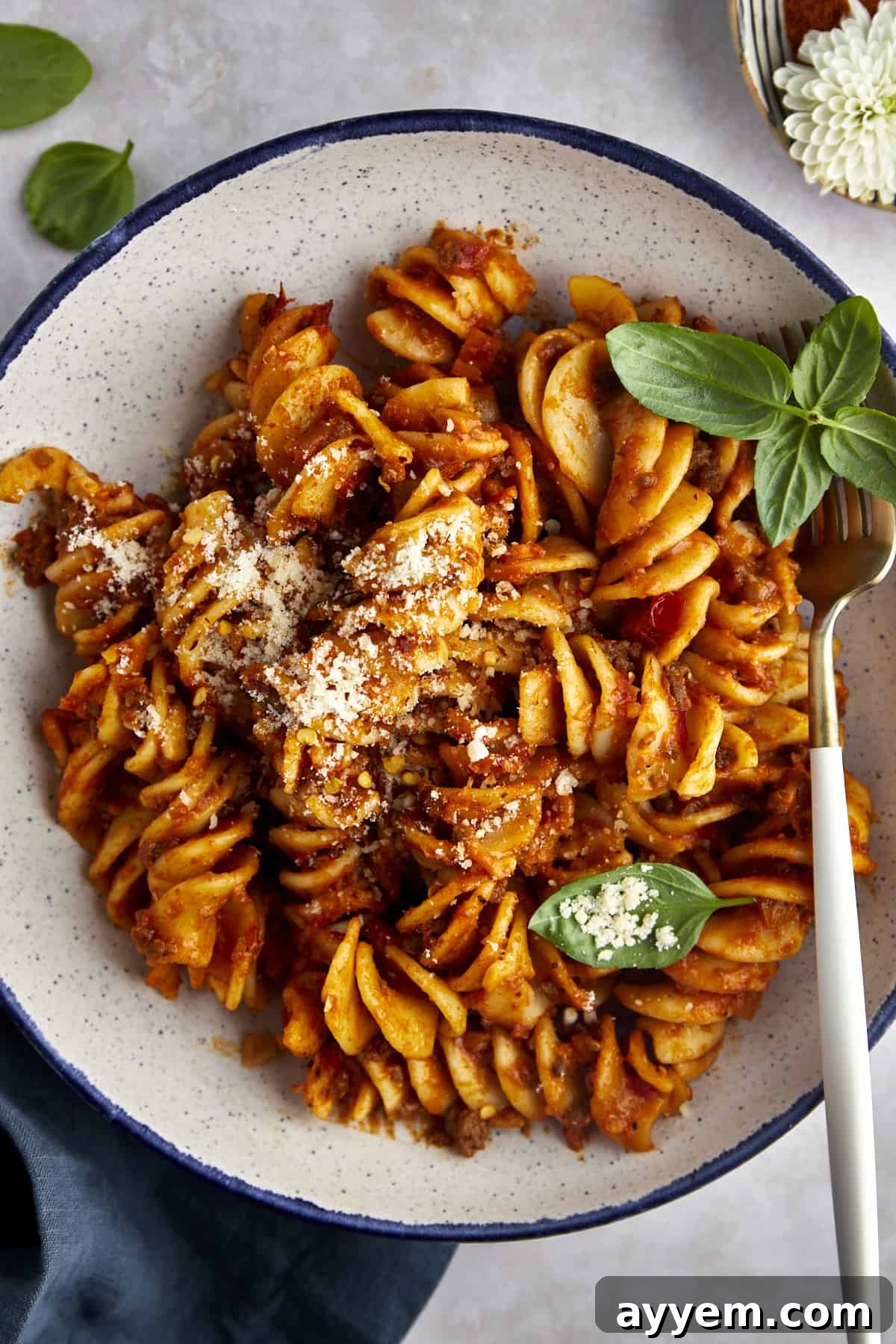 Overhead image of a bowl of taco pasta topped with Parmesan cheese. 