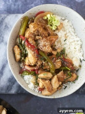 a bowl of white rice topped with black pepper chicken stir fry