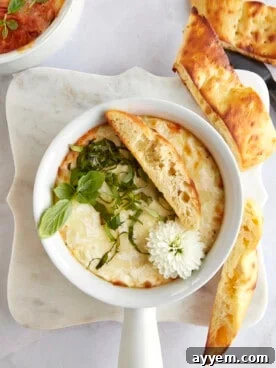 Overhead image of a ramekin of Eggs in Purgatory with a piece of bread on top.