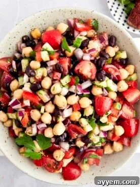 A bowl of Balela Salad with black beans, chickpeas, and veggies.