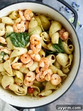 Vibrant one-pot pesto pasta with succulent oven-baked shrimp, garnished with fresh basil