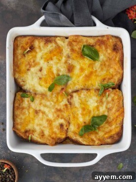 Four baked easy chicken fajita sandwiches topped with golden melted cheese, served in a white baking dish