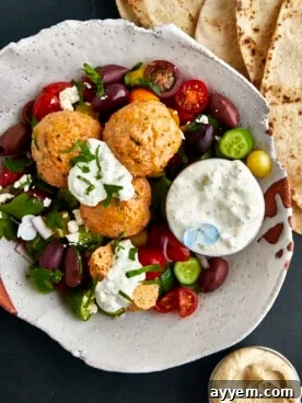 Flavorful Chicken Shawarma Meatballs served with fresh vegetables and tzatziki sauce.