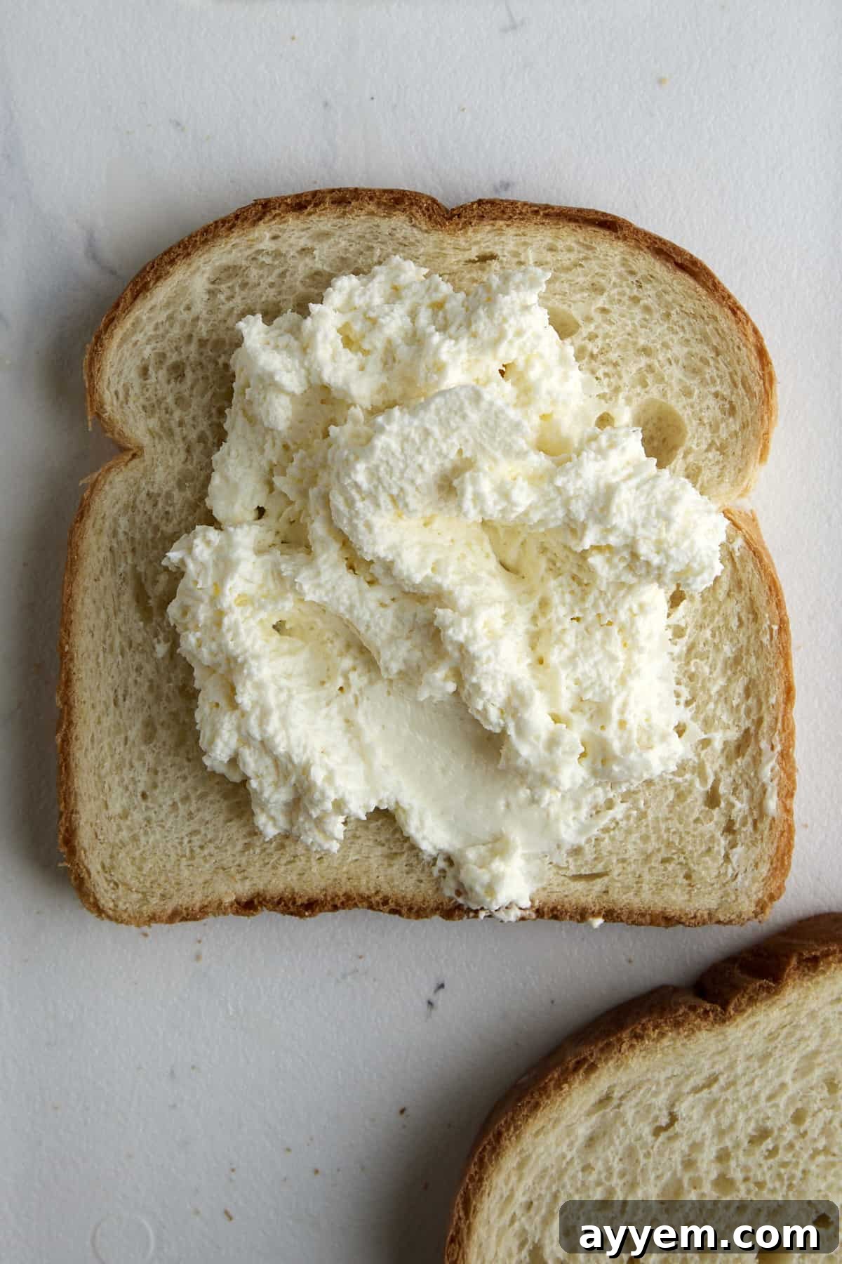 Whipped cream cheese on a piece of bread. 