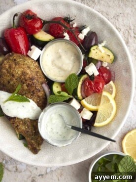 Overhead image of a colorful bowl of Za'atar Chicken with roasted vegetables like bell peppers and zucchini.