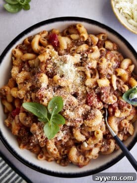 A hearty bowl of slow cooker ground beef pasta topped with grated Parmesan and fresh parsley, a perfect fuss-free comfort food.