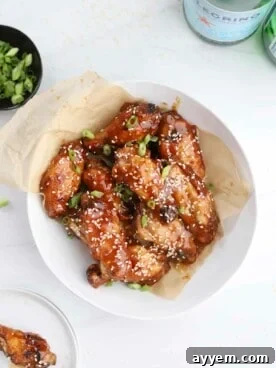 A tempting bowl of air fryer honey garlic chicken wings, perfectly crispy and sticky, garnished with sesame seeds.