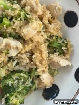 A vibrant bowl of chicken and broccoli rice, featuring tender chicken pieces, bright green broccoli florets, and fluffy rice, garnished with fresh herbs.