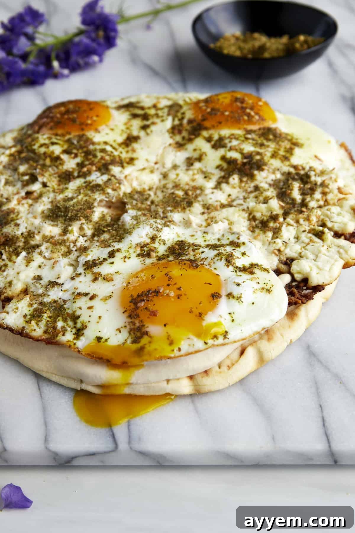 Fried feta eggs topped with za'atar and served over toasted pita with hummus.