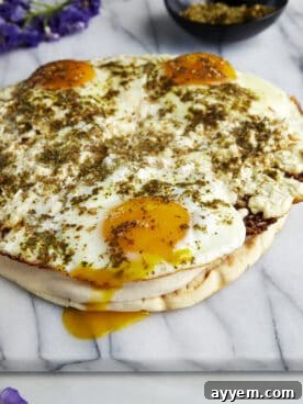 Fried feta eggs topped with za'atar and served over toasted pita with hummus.