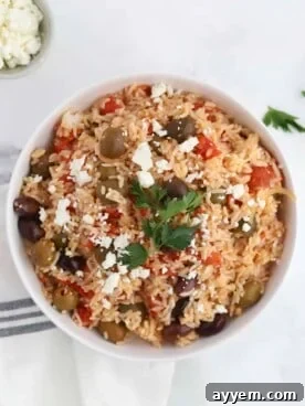 a bowl of Greek rice bake topped with feta and fresh herbs