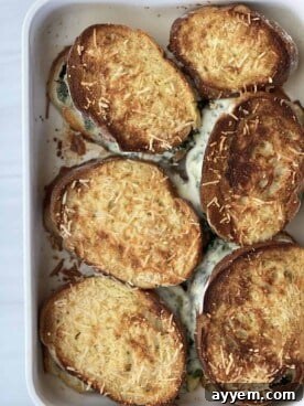 A golden-brown grilled cheese sandwich, oozing with a spinach and feta filling, reminiscent of spanakopita.