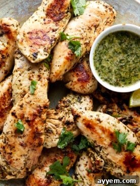 A basket of perfectly cooked lime chicken tenders, glistening with a savory citrus marinade, served with a side of dipping sauce.