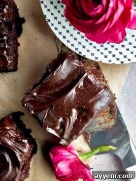 A decadent square of rich chocolate zucchini cake, generously topped with a swirl of chocolate frosting.
