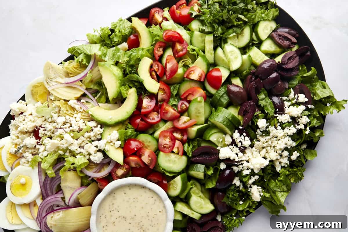 Vibrant Mediterranean Cobb 3 Middle Eastern Cobb Salad with a container of dressing on the side.