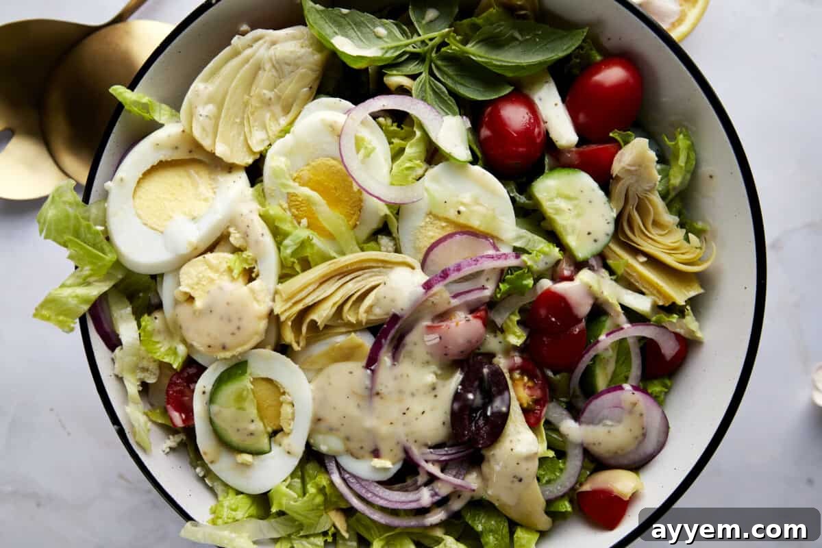 Vibrant Mediterranean Cobb 4 A bowl of Middle Eastern Cobb Salad topped with dressing.
