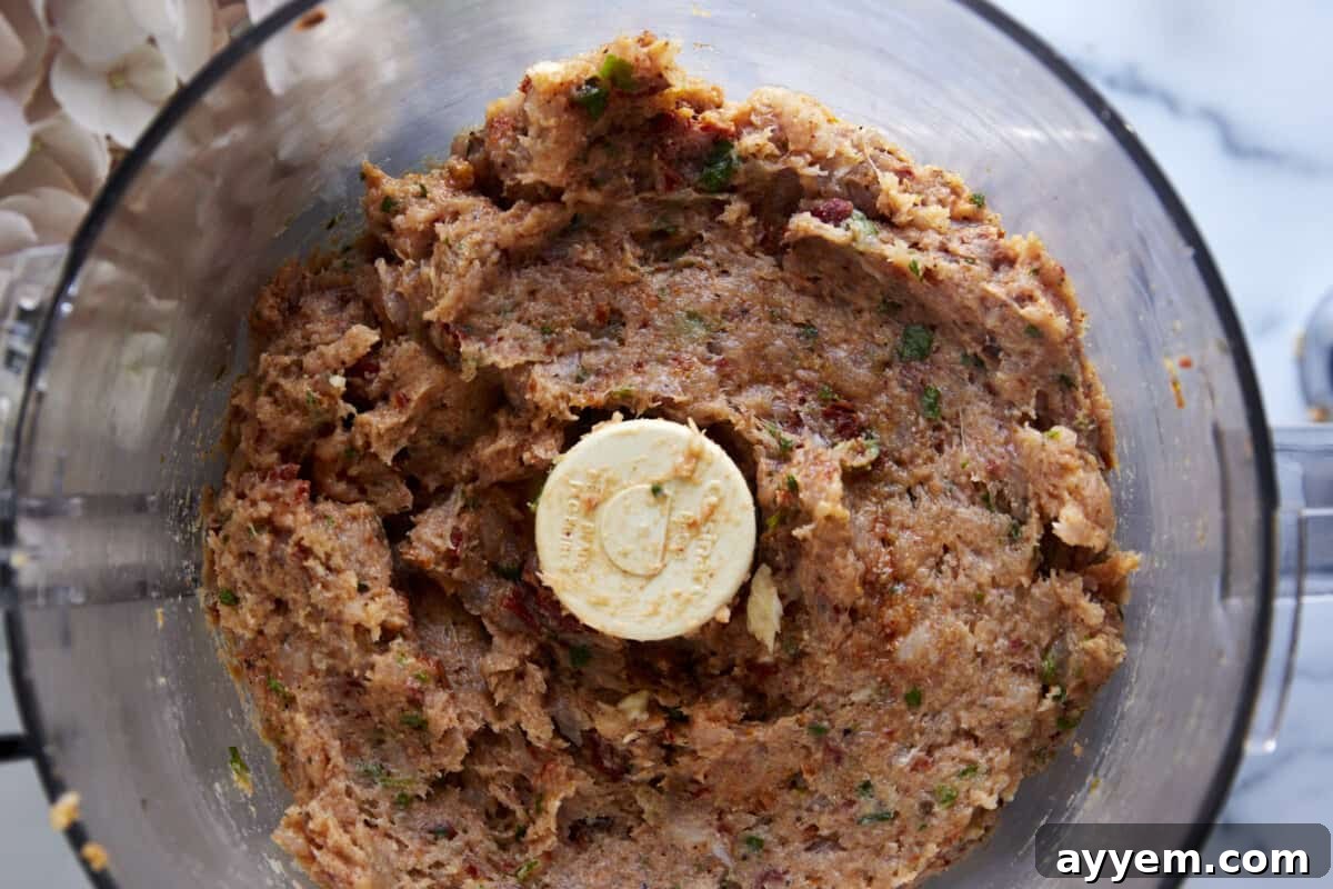 Raw chicken meatball mixture in a food processor. 