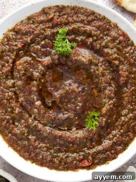 A vibrant bowl of Turkish ezme, a fresh and spicy salad appetizer, garnished with parsley.