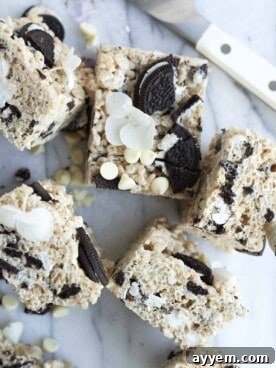 Six delicious Oreo Rice Krispie Treats, adorned with white chocolate chips and chunks of Oreo cookies.