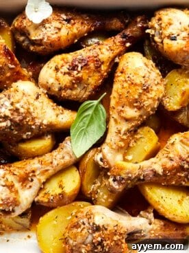 Garlic Parmesan Chicken Drumsticks with Potatoes on a baking sheet.