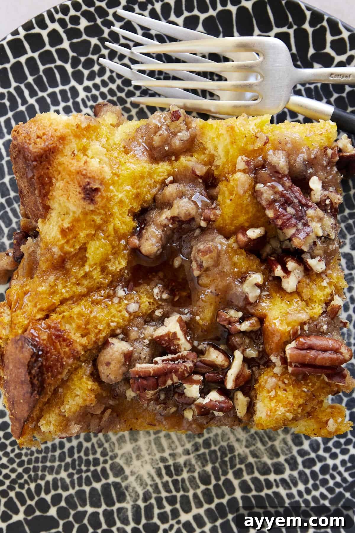 A close-up of the perfectly baked Pumpkin French Toast Casserole, showcasing its golden-brown streusel topping and soft interior.